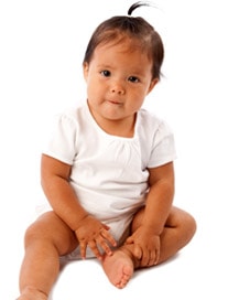 Baby girl with pony tail in white